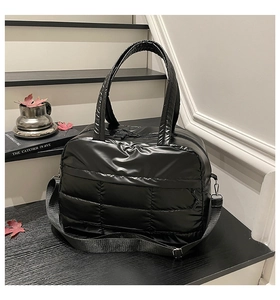 Close-up of black quilted nylon tote bag with glossy finish and detachable shoulder strap