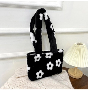 Détail de la texture du sac cabas en peluche noir avec motif floral blanc sur tricot
