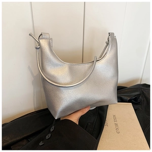 Detail of silver crescent tote bag showing pearlescent leather texture and slim handle