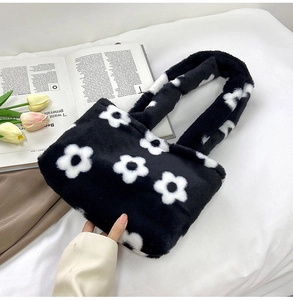 Détail macro du sac cabas en peluche avec motif de fleurs blanches et texture douce