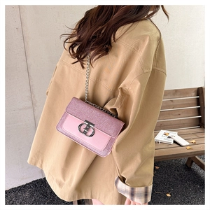 Pink sequin crossbody bag with silver chain and metal buckle shown on a shoulder