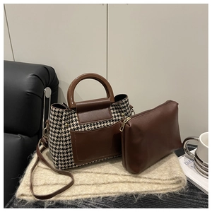 Détail du sac cabas à motif pied-de-poule et sa pochette assortie sur une écharpe