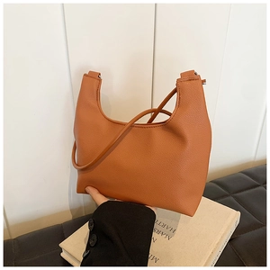 Close-up of brown litchi pattern leather texture and hobo style shoulder bag strap