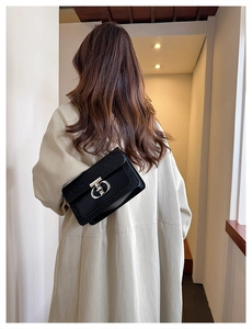 Detail of a black sequined texture shoulder bag with silver geometric swivel lock