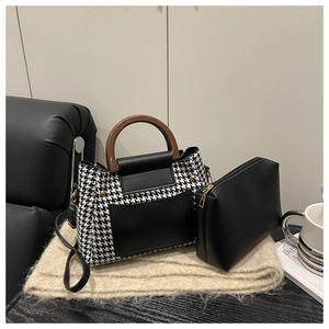 Détail du sac à main pied-de-poule avec poignée en simili bois et pochette assortie