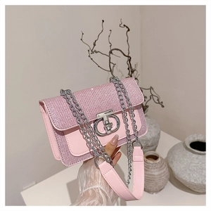 Detail of pink rhinestone shoulder bag featuring silver chain strap and twist lock clasp