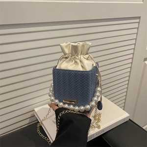 Sac seau bleu à texture tissée avec poignée en perles élégante et bandoulière dorée