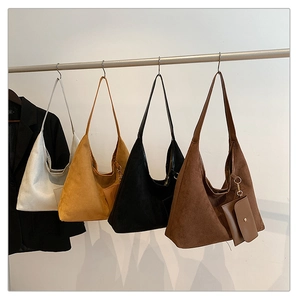 Frosted suede shoulder bags in four colors with matching coin purses on display
