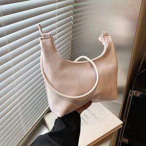 Minimalist cream litchi grain leather crescent underarm tote bag shown in a lifestyle setting