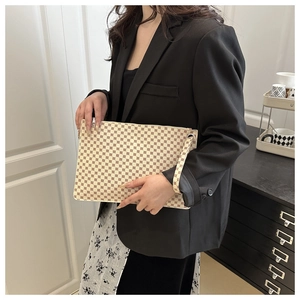 Detailed view of beige monogram envelope clutch bag with red-brown vintage pattern