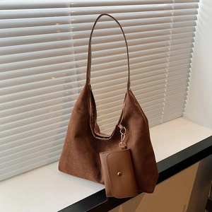 Vintage brown suede large hobo tote bag with a matching mini pouch on a white windowsill
