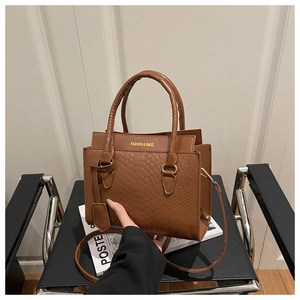 Detail of caramel brown woven leather bag with Fashion & Bags text on a designer chair