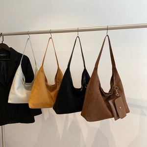Minimalist large suede tote bags in four colors hanging on a metal rack for women