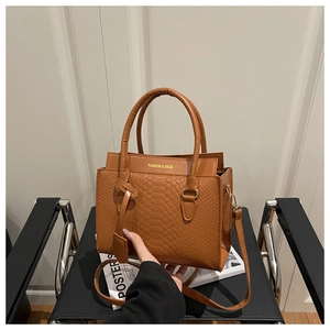 Detail of caramel brown crocodile texture leather handbag with adjustable strap