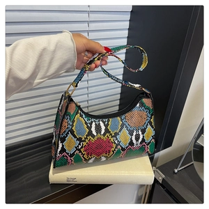 Detailed close-up of a colorful snakeskin embossed baguette bag with metallic rings