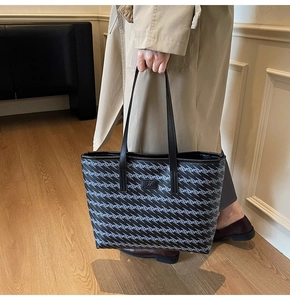 Detail of large tote bag with blue geometric wavy patterns and brand logo in street style