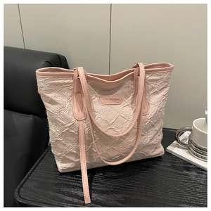 Close-up of pink tote bag with floral embroidery and Tidal Dryness leather label