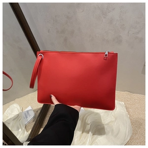 Detail of red minimalist tote with matte faux leather and silver zipper closure