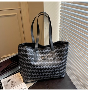 Detail of a large tote bag with black and white wavy geometric patterns and PU leather straps