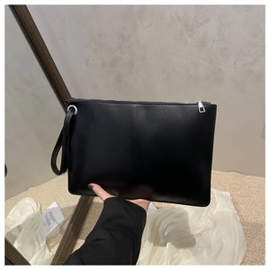 Minimalist black matte leather clutch with silver zipper and practical wrist strap handle