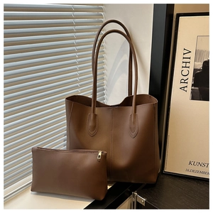 Detail view of large brown faux leather tote bag with matching zippered pouch set