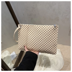 Detailed view of cream envelope clutch bag with red-brown geometric patterns and silver zipper
