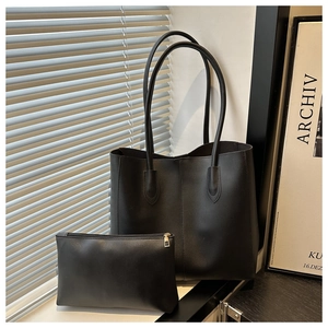 Detail of minimalist black tote bag and matching zipper pouch in natural shadow