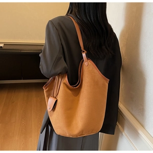 Brown suede tote bag detail showing large capacity design and leather piping trim
