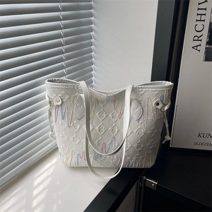White tote bag with textured letter embossing and colorful wavy embroidery detail