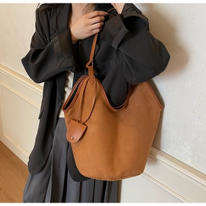 Brown suede tote bag shown on shoulder with minimalist business casual outfit