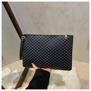 Close-up of black envelope clutch with blue dotted patterns and silver metal zipper