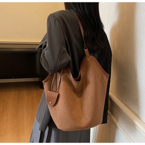 Detail view of large dark brown suede tote bag with small matching pouch for women