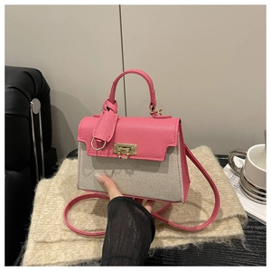 Detailed shot of pink leather and beige canvas stitching with gold metal clasp closure