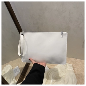 Detail of white faux leather clutch bag with silver zipper and wrist strap in hand
