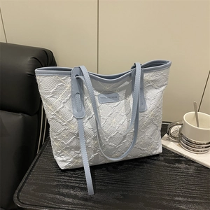 Light blue embroidered tote bag with white floral patterns and Tidal Dryness label