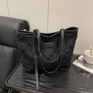 Chic black large tote bag with sequined pleated texture and leather brand label