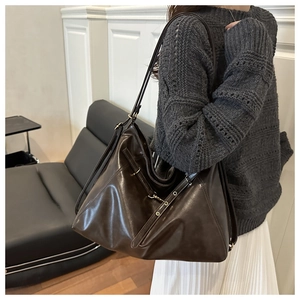 Detail of soft glossy dark brown leather tote bag with decorative adjustable straps