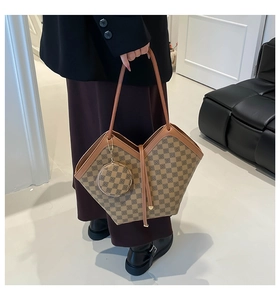 Close-up of geometric pattern tote bag with brown trim and round hanging coin purse