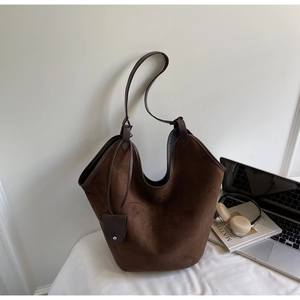 Detail of dark brown suede tote bag featuring a minimalist design and soft matte texture
