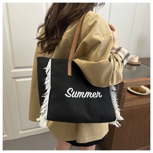 Détail du sac cabas en toile noire avec broderie Summer blanche et bordures à franges