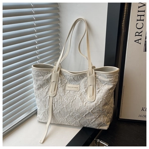 Dettaglio della borsa tote bianca con texture a pieghe e ricamo Tidal Dryness