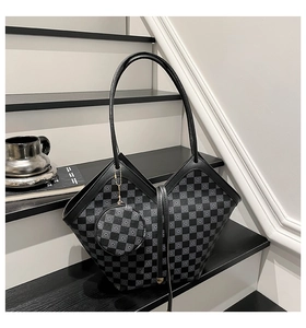 Detail of checkered bucket bag with a matching round coin purse on a minimalist staircase