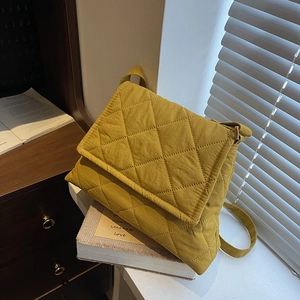 Quilted mustard yellow crossbody bag with rhombus stitching and adjustable strap