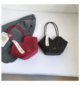 Detail of tweed bucket bag with V-shaped opening, fashion tags and chic ribbon charm