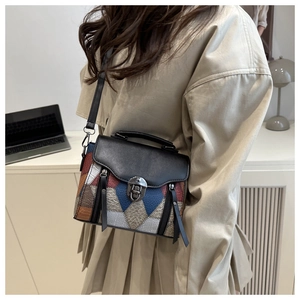 Detail of a retro patchwork leather crossbody bag with vintage metal lock on a model
