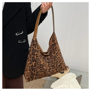 Detail shot of the large leopard print tote bag with brown leather strap and suede texture