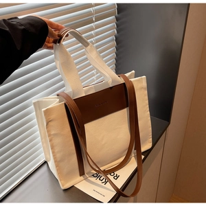 Close-up of contrast stitching canvas tote with FASHION & BAG embossing and PU leather straps