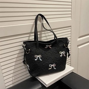 Chic black quilted tote bag with colorful embroidered bows and leather shoulder straps