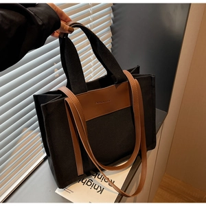 Detail of canvas tote bag with brown faux leather handles and fashion printed lettering
