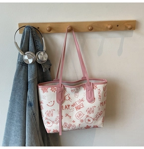 Detail of white tote bag with red cartoon graffiti prints and pink shoulder straps
